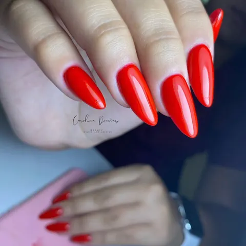 Uñas rojas en forma de almendra con acabado brillo